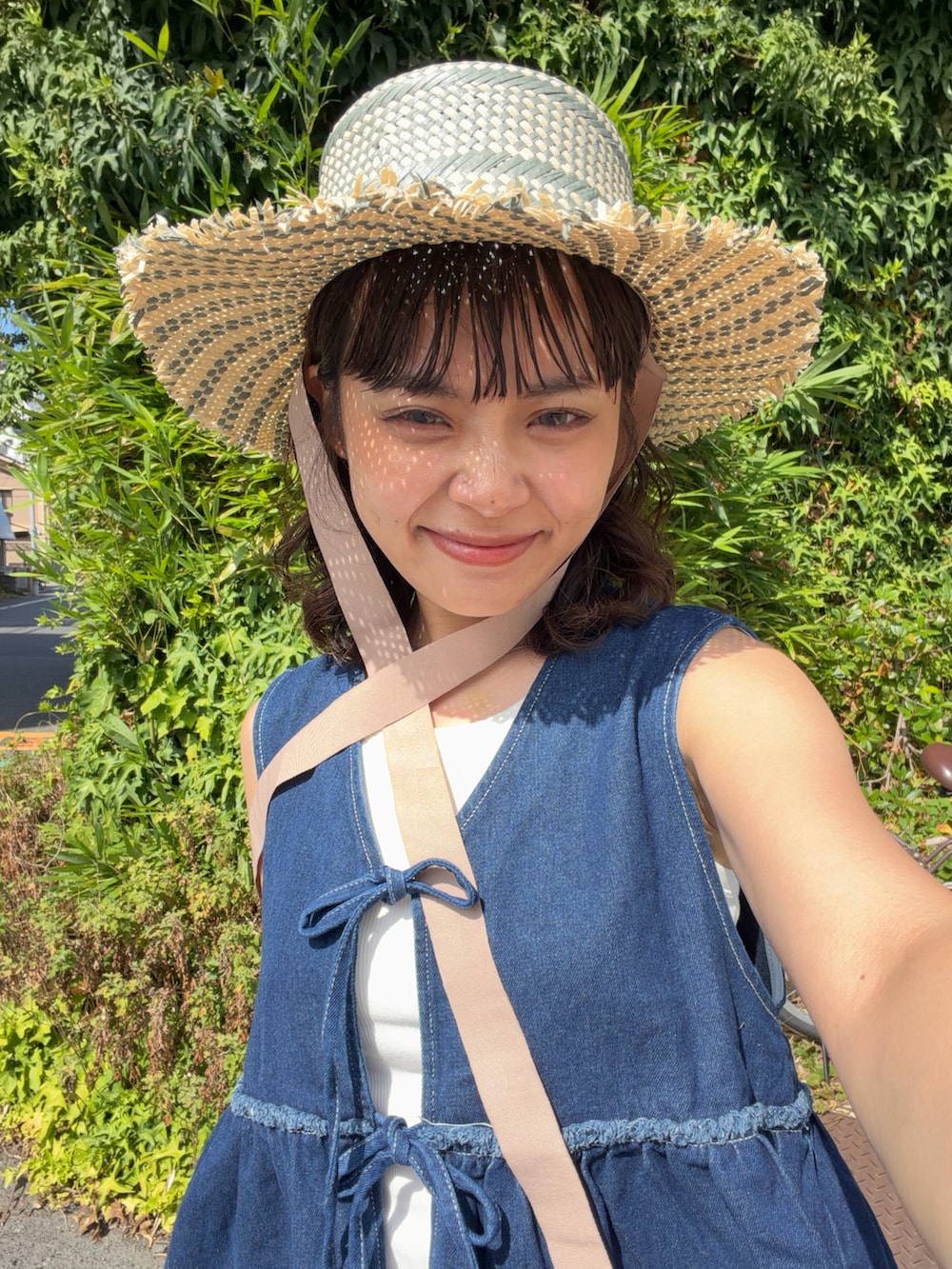 ブルー系のワンピース、ブラック系のハンドバッグ、ブラック系のサンダルを着用したレディースの夏コーディネートの3枚目の写真