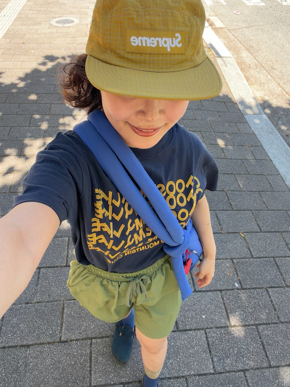 ブルー系のTシャツ/カットソー、グリーン系のパンツ、ブルー系のハンドバッグを着用したレディースの夏コーディネートの4枚目の写真