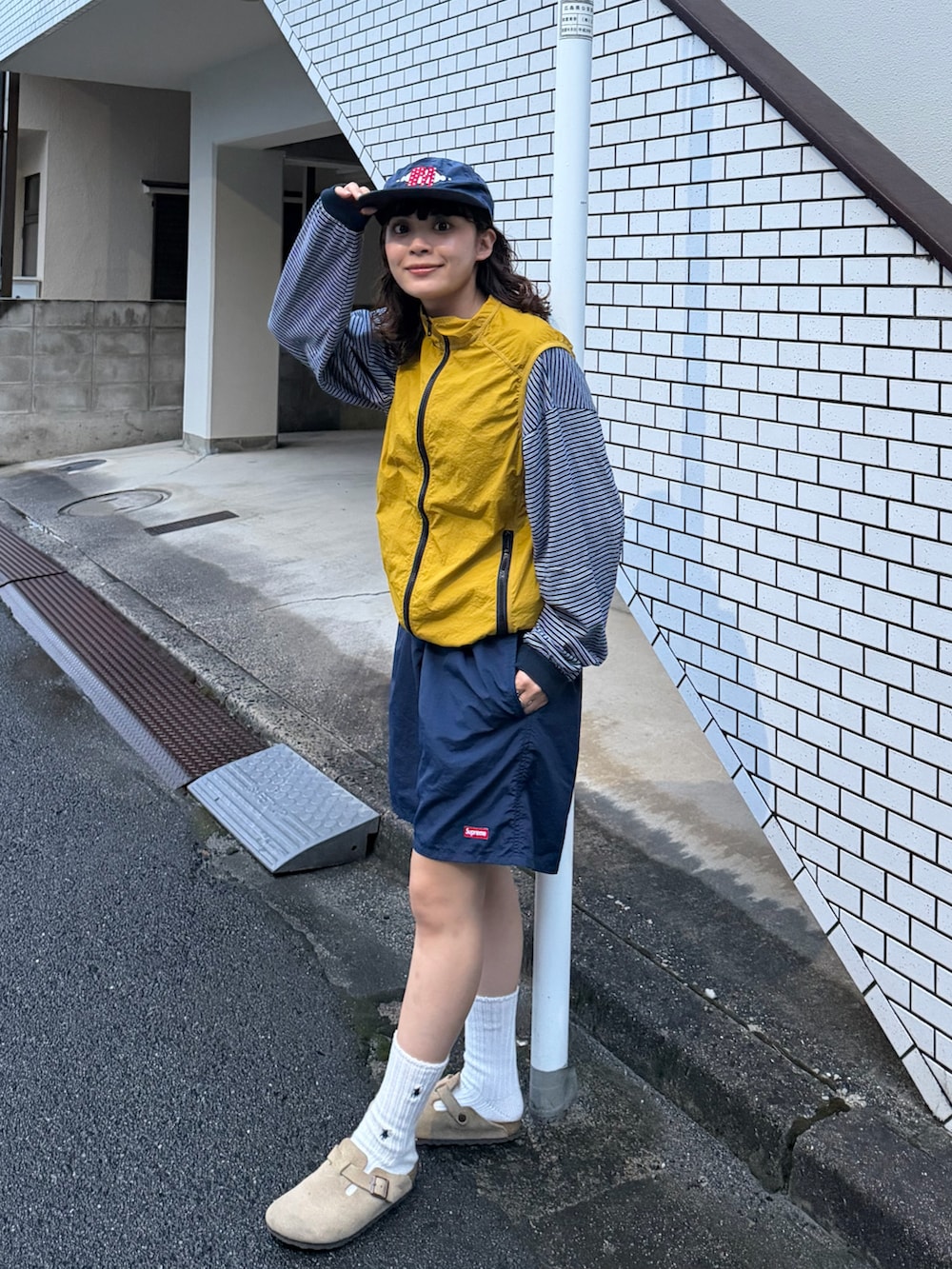 ブルー系のTシャツ/カットソー、ベージュ系のサンダル、ブラック系のトップスを着用したレディースの秋コーディネートの2枚目の写真