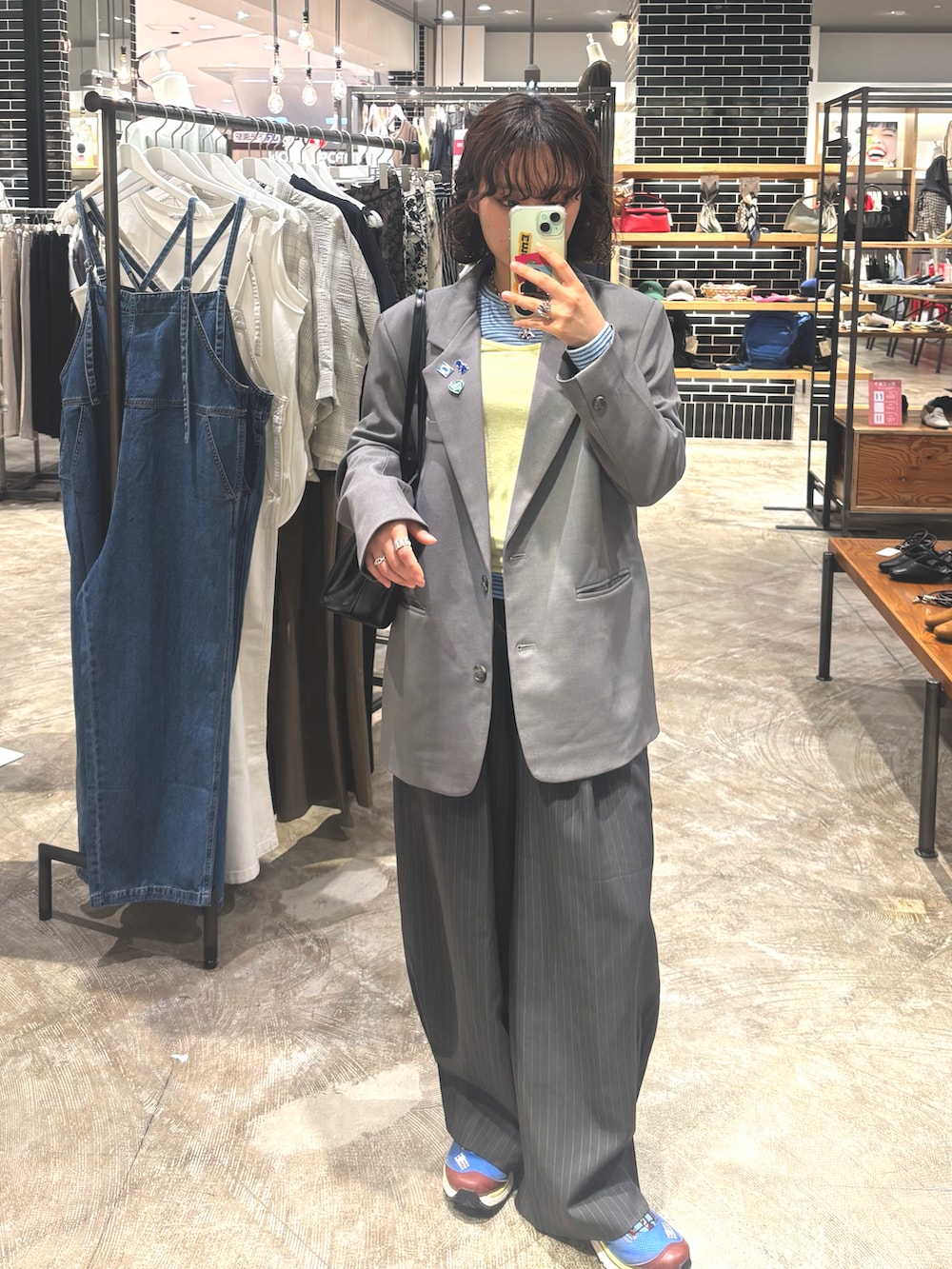 イエロー系のトップス、ブルー系のトップス、グレー系のノーカラージャケットを着用したレディースの春コーディネートの3枚目の写真