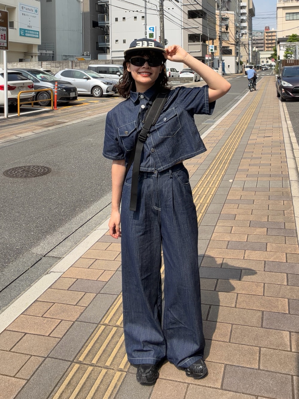 ブルー系のトップス、ブルー系のパンツ、ブラック系のボディバッグ/ウエストポーチを着用したレディースの夏コーディネートの2枚目の写真