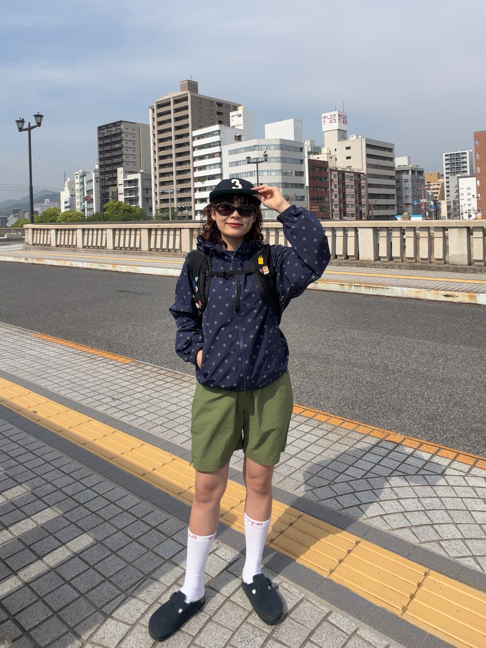 ブラック系のバックパック/リュック、ブルー系のサンダル、ブルー系のジャケット/アウターを着用したレディースの春コーディネートの2枚目の写真