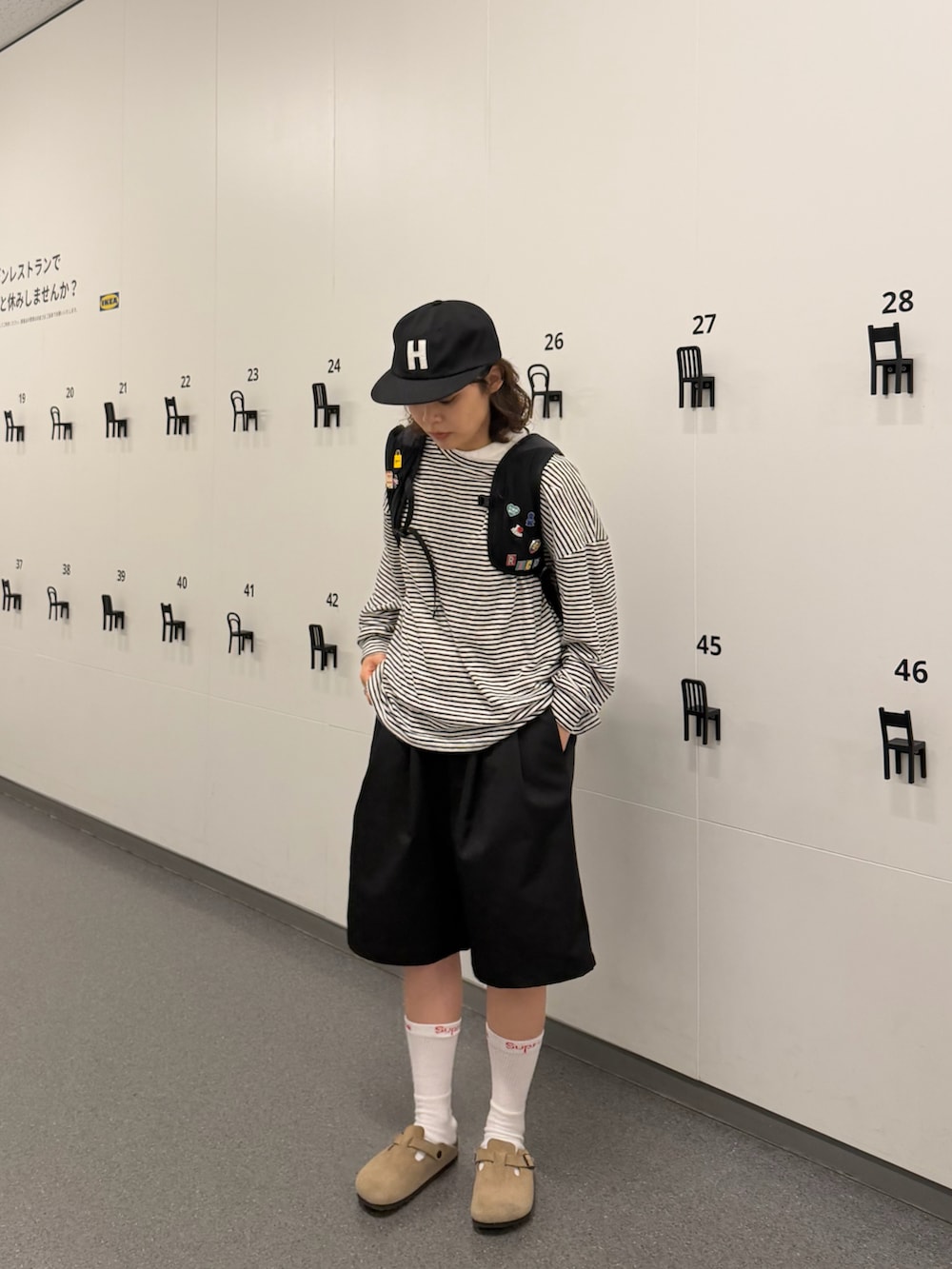 ベージュ系のサンダル、ブラック系のバックパック/リュック、ブラック系のトップスを着用したレディースの春コーディネートの3枚目の写真