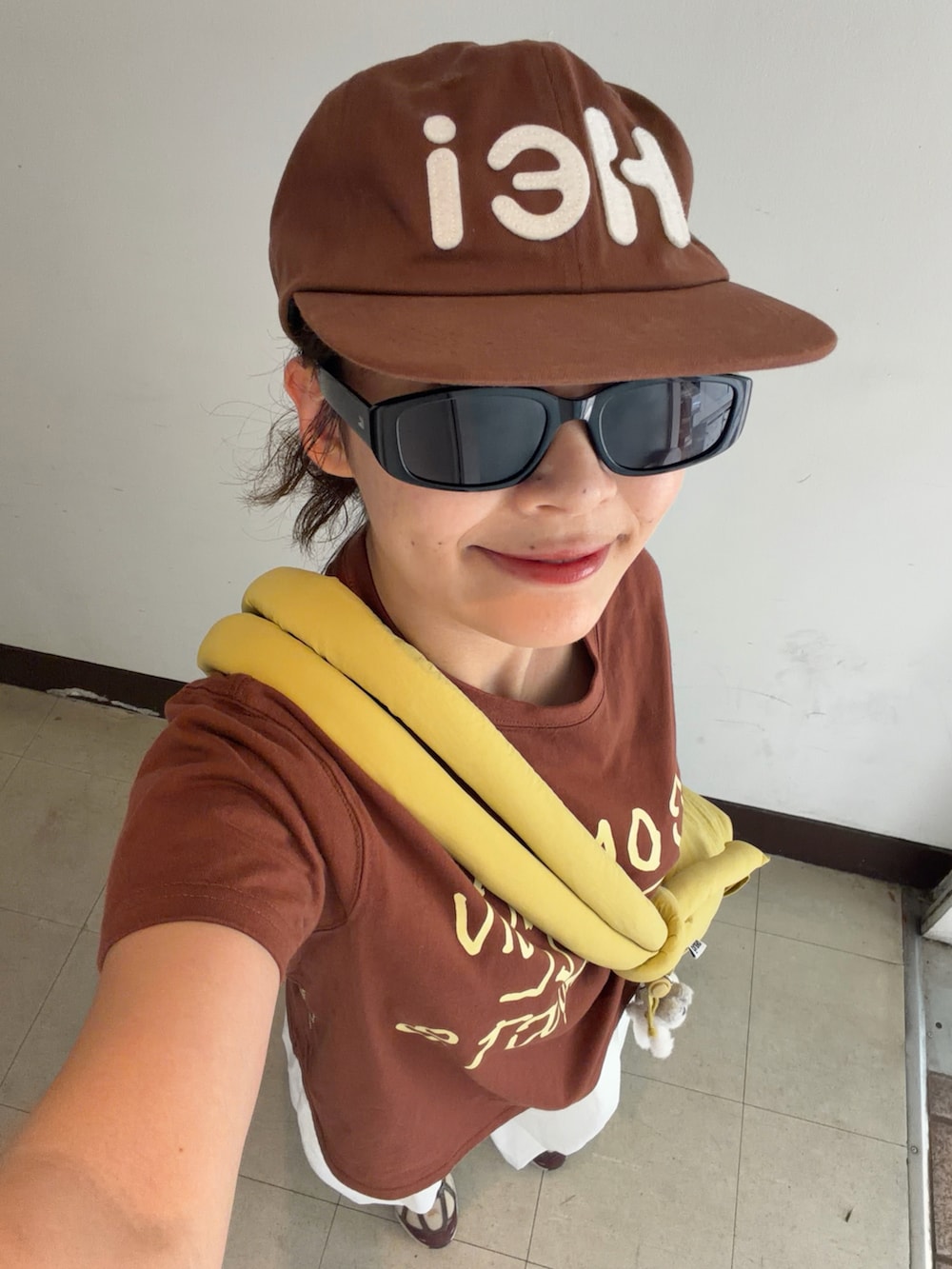 ブラウン系のTシャツ/カットソー、イエロー系のハンドバッグ、ホワイト系のパンツを着用したレディースの夏コーディネートの3枚目の写真