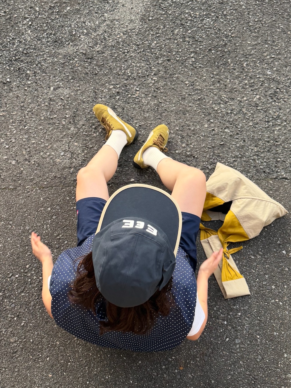 ブルー系のベスト、イエロー系のバッグ、ホワイト系のTシャツ/カットソーを着用したレディースの夏コーディネートの3枚目の写真
