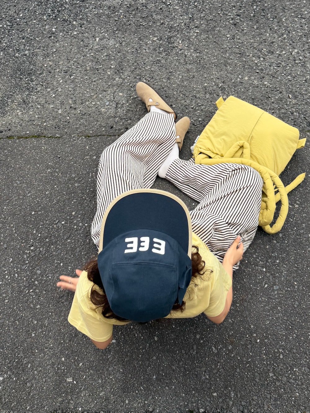 イエロー系のTシャツ/カットソー、ベージュ系のサンダル、ホワイト系のパンツを着用したレディースの夏コーディネートの3枚目の写真