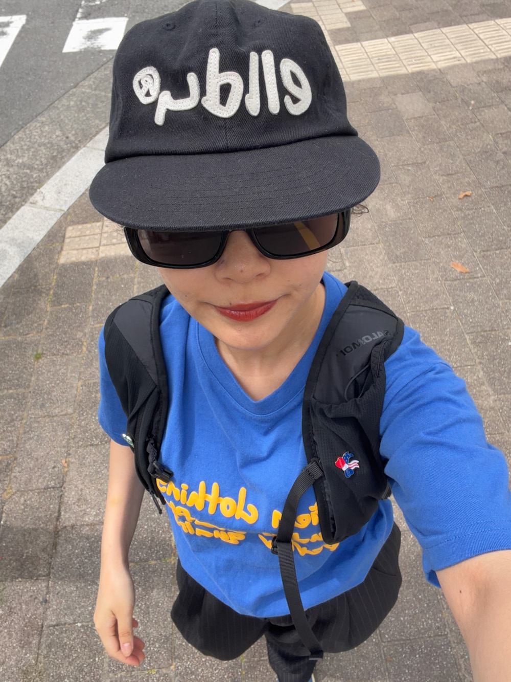 ブルー系のTシャツ/カットソー、ブラック系のパンツ、ブルー系のシューズを着用したレディースの夏コーディネートの3枚目の写真