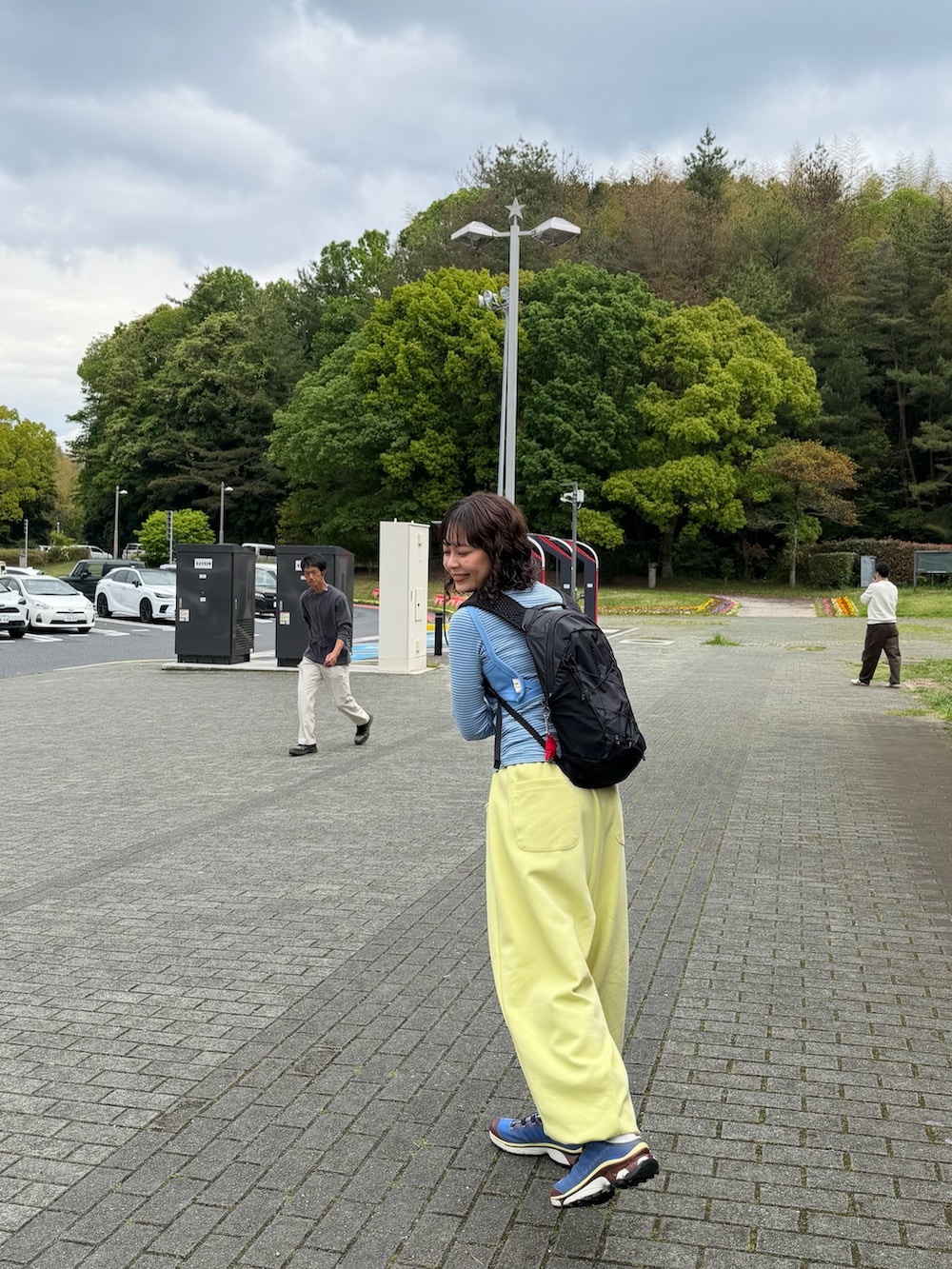 イエロー系のスウェットパンツ、ブルー系のシューズ、ブルー系のキャミソールを着用したレディースの春コーディネートの2枚目の写真