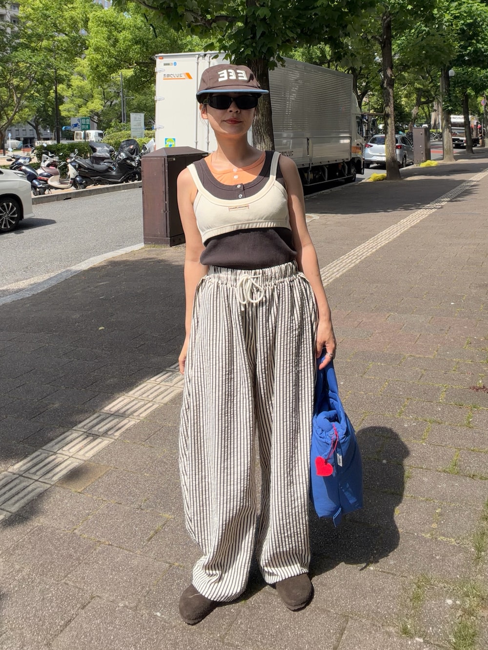 ホワイト系のキャミソール、グレー系のタンクトップ、ホワイト系のパンツを着用したレディースの夏コーディネートの3枚目の写真