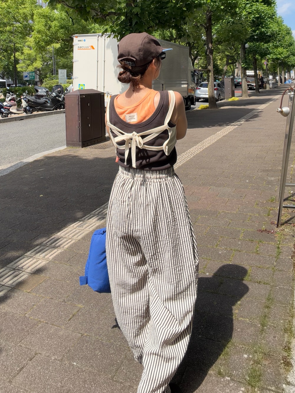 ホワイト系のキャミソール、グレー系のタンクトップ、ホワイト系のパンツを着用したレディースの夏コーディネートの2枚目の写真