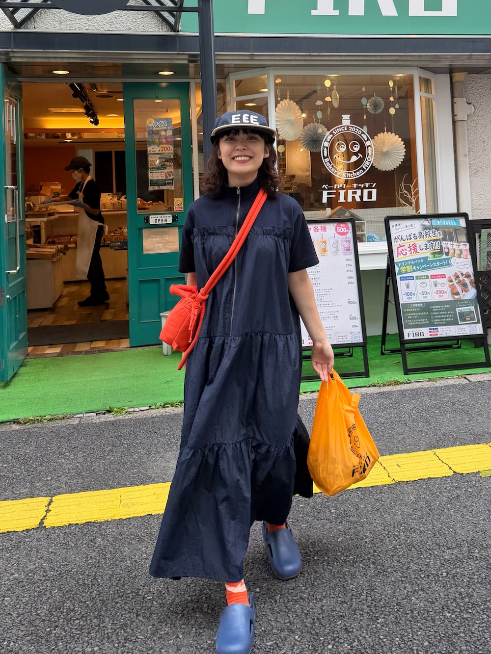 ブルー系のワンピース、オレンジ系のハンドバッグ、ブルー系のシューズを着用したレディースの夏コーディネートの3枚目の写真
