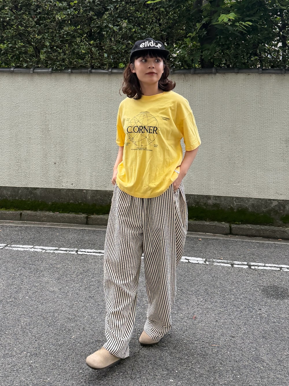 イエロー系のTシャツ/カットソー、ベージュ系のサンダル、ホワイト系のパンツを着用したレディースの夏コーディネートの2枚目の写真