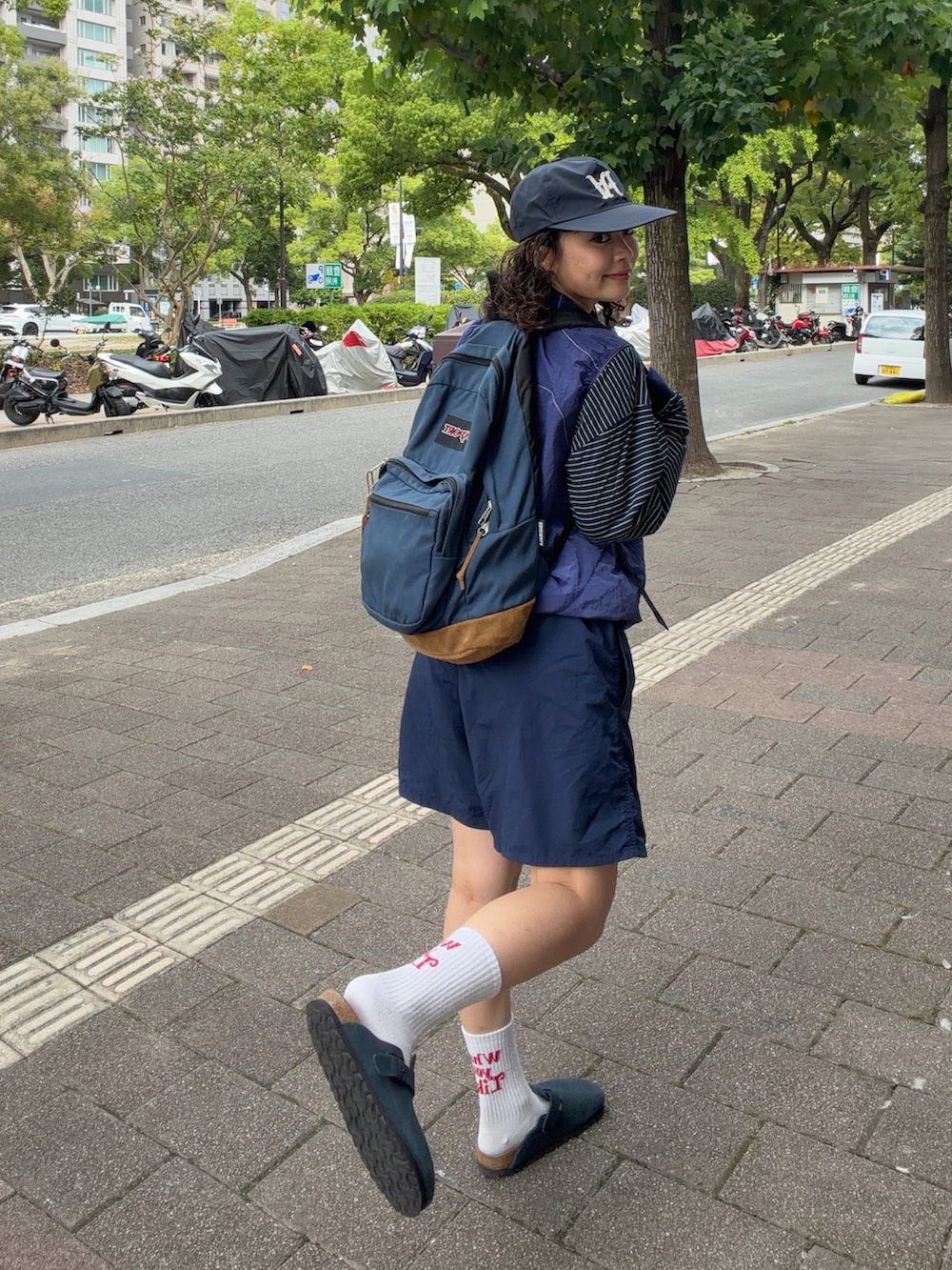 イエロー系のトップス、ブルー系のTシャツ/カットソー、ブルー系のパンツを着用したレディースの秋コーディネートの3枚目の写真