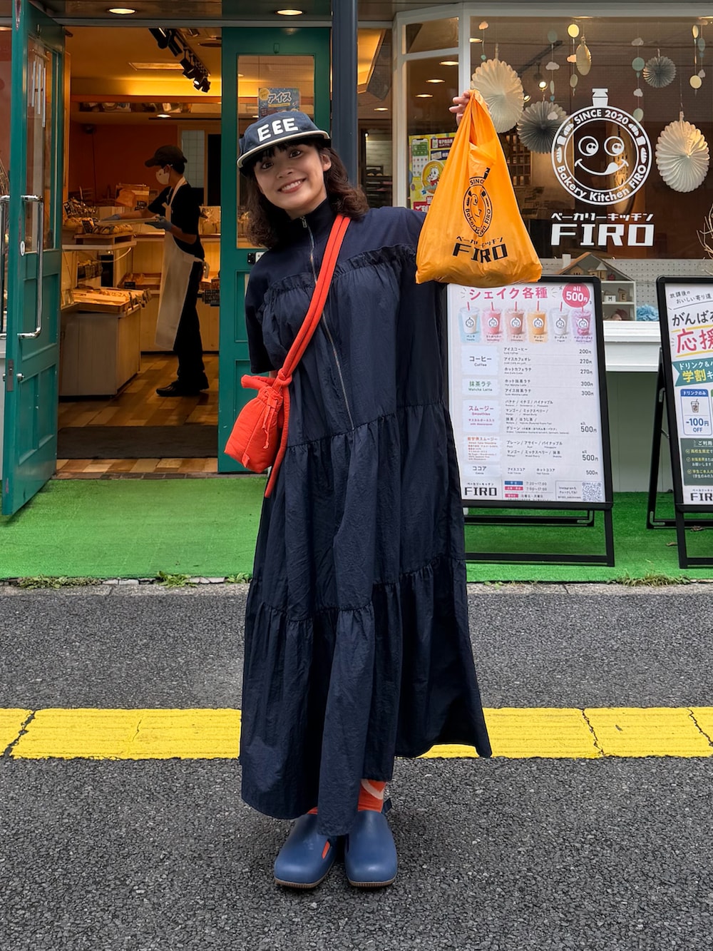 ブルー系のワンピース、オレンジ系のハンドバッグ、ブルー系のシューズを着用したレディースの夏コーディネートの2枚目の写真