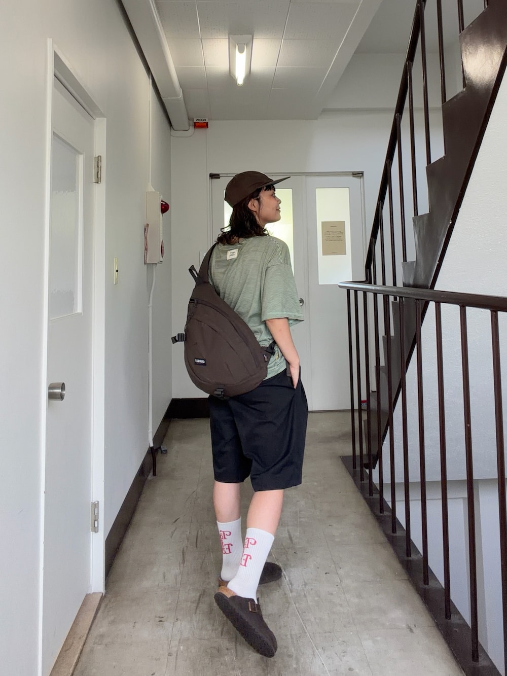 グリーン系のTシャツ/カットソー、ブラック系のパンツ、ブラウン系のサンダルを着用したレディースの夏コーディネートの3枚目の写真