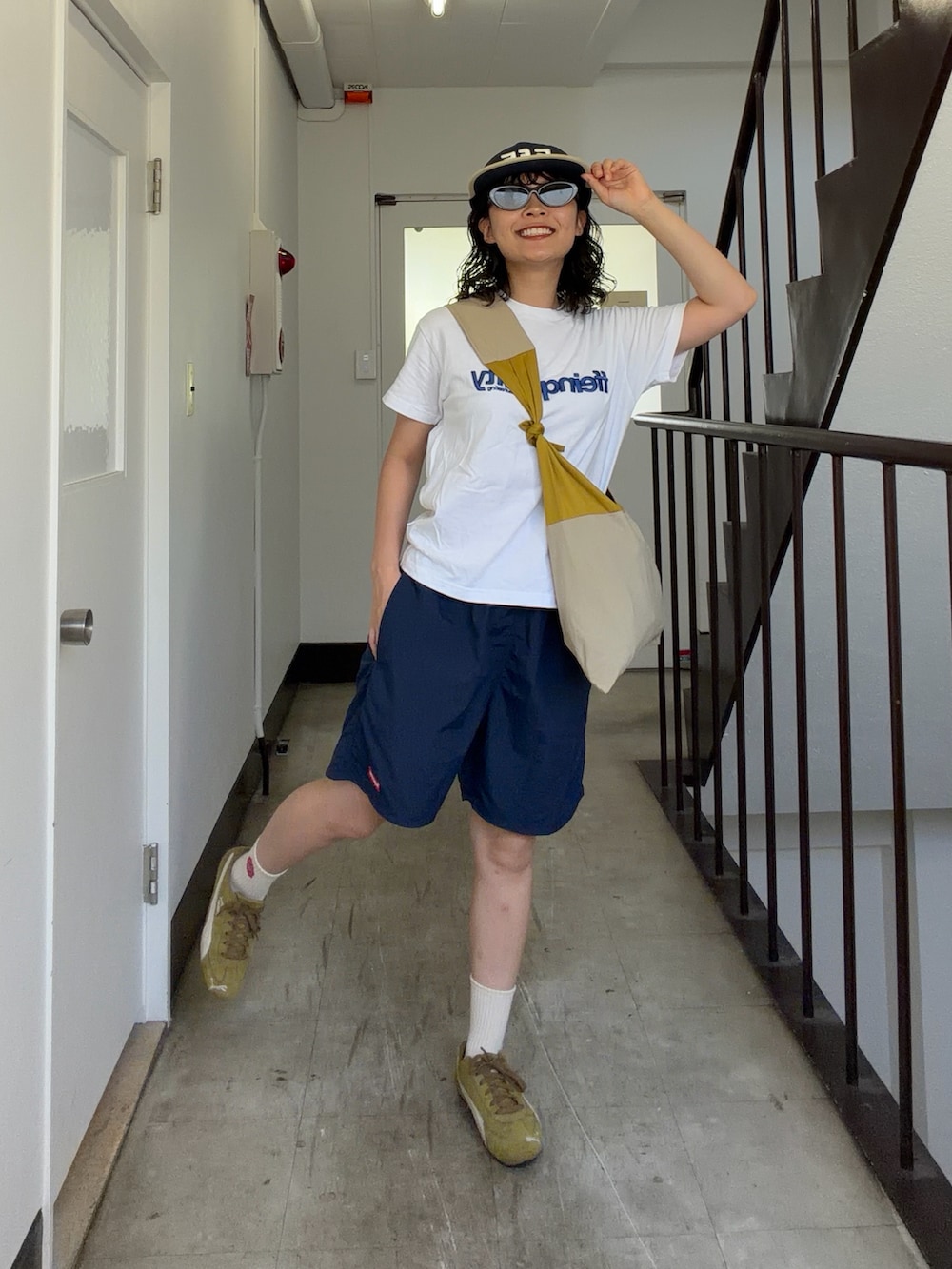 ホワイト系のTシャツ/カットソー、ブルー系のパンツ、イエロー系のバッグを着用したレディースの夏コーディネートの2枚目の写真