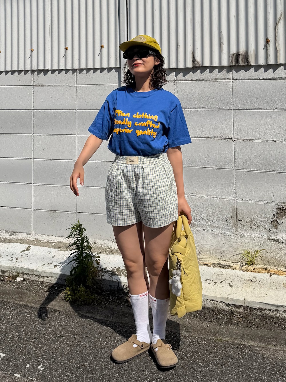 ブルー系のTシャツ/カットソー、イエロー系のその他パンツ、イエロー系のハンドバッグを着用したレディースの春コーディネートの2枚目の写真