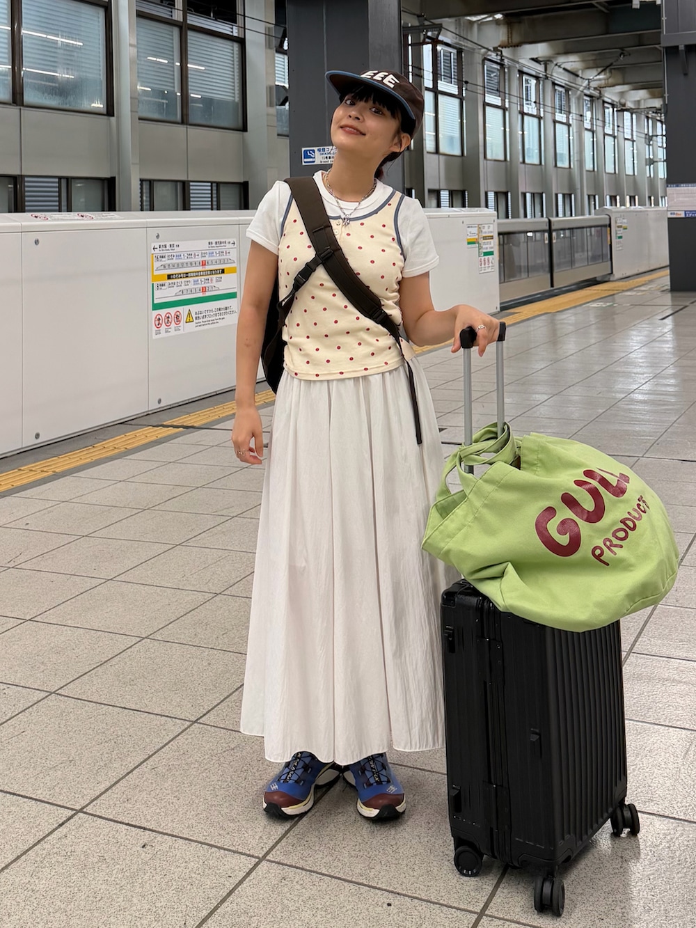 レッド系のタンクトップ、ホワイト系のスカート、ブルー系のシューズを着用したレディースの夏コーディネートの2枚目の写真