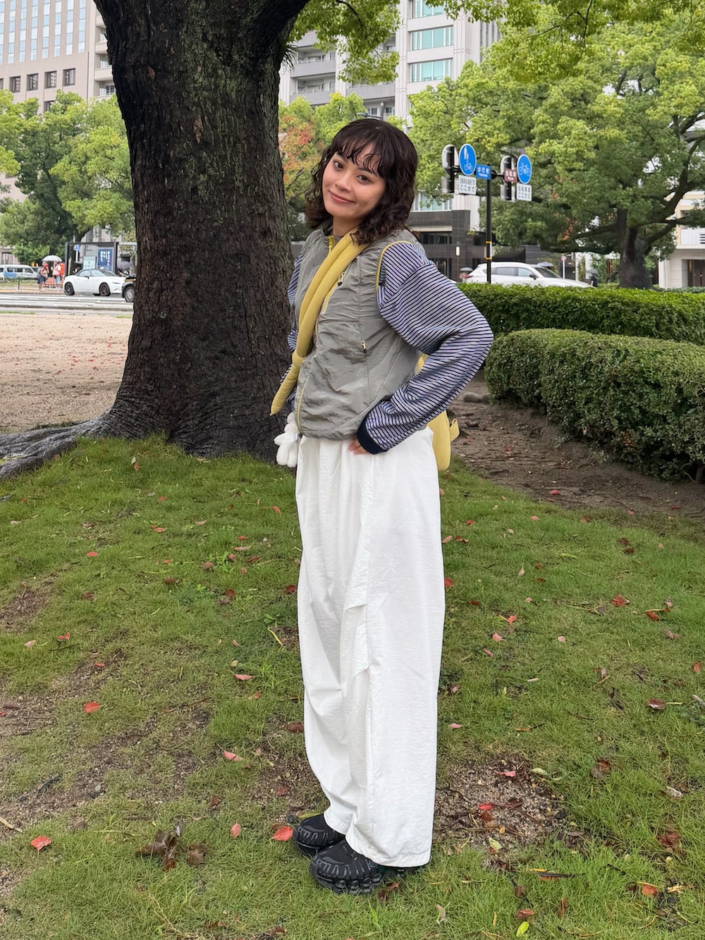 ブラック系のスニーカー、ブルー系のTシャツ/カットソー、イエロー系のハンドバッグを着用したレディースの秋コーディネートの3枚目の写真