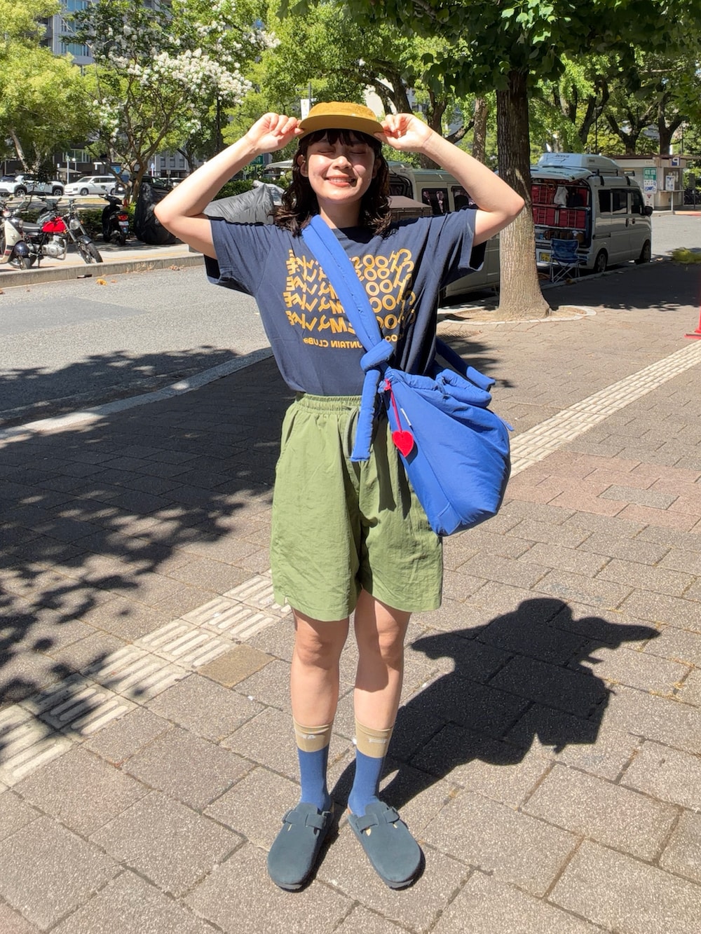ブルー系のTシャツ/カットソー、グリーン系のパンツ、ブルー系のハンドバッグを着用したレディースの夏コーディネートの2枚目の写真