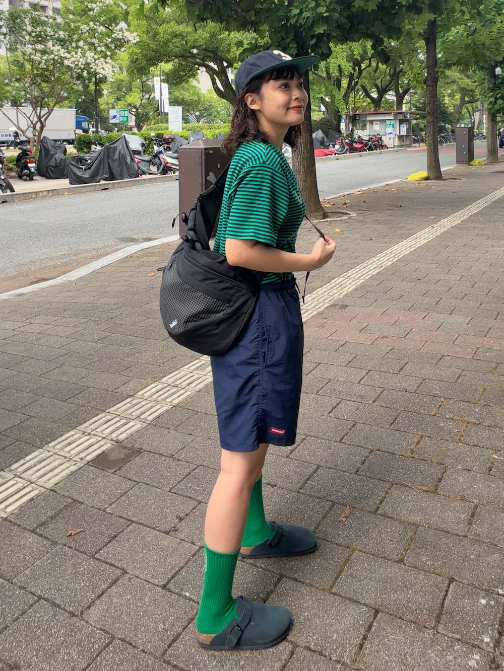 グリーン系のTシャツ/カットソー、ブルー系のパンツ、ブルー系のサンダルを着用したレディースの夏コーディネートの2枚目の写真