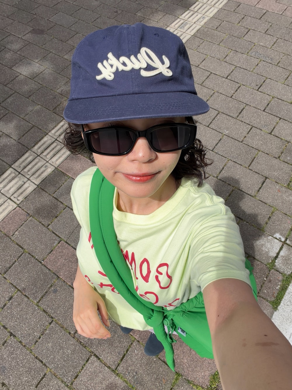 ブルー系のサンダル、グリーン系のTシャツ/カットソー、グリーン系のハンドバッグを着用したレディースの夏コーディネートの3枚目の写真