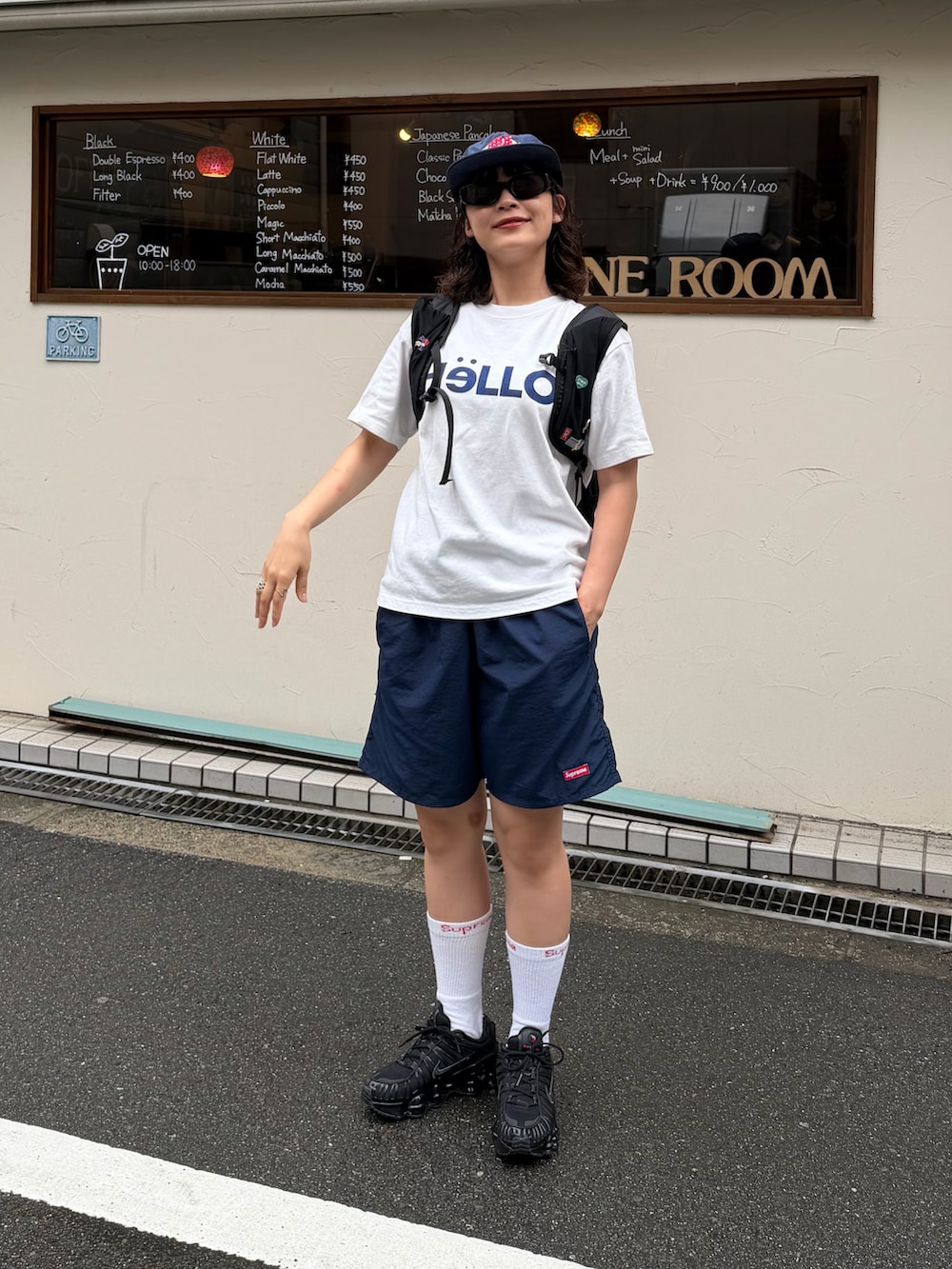 ブラック系のスニーカー、ブラック系のバックパック/リュック、ホワイト系のTシャツ/カットソーを着用したレディースの夏コーディネートの2枚目の写真