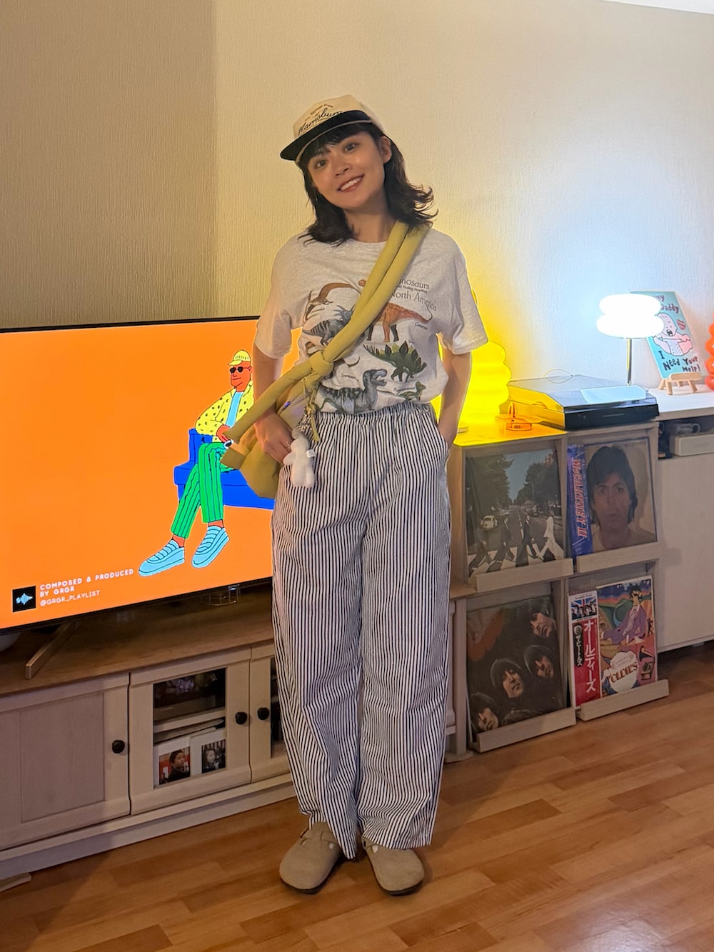 シルバー系のTシャツ/カットソー、イエロー系のハンドバッグ、ホワイト系のパンツを着用したレディースの夏コーディネートの2枚目の写真