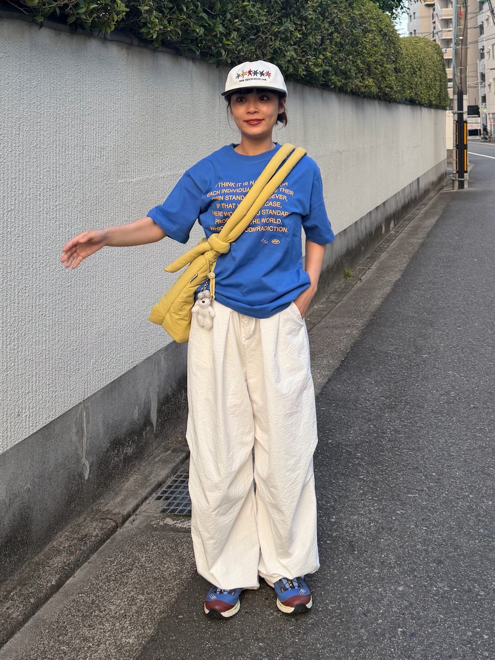 ブルー系のTシャツ/カットソー、イエロー系のハンドバッグ、ホワイト系のパンツを着用したレディースの夏コーディネートの2枚目の写真