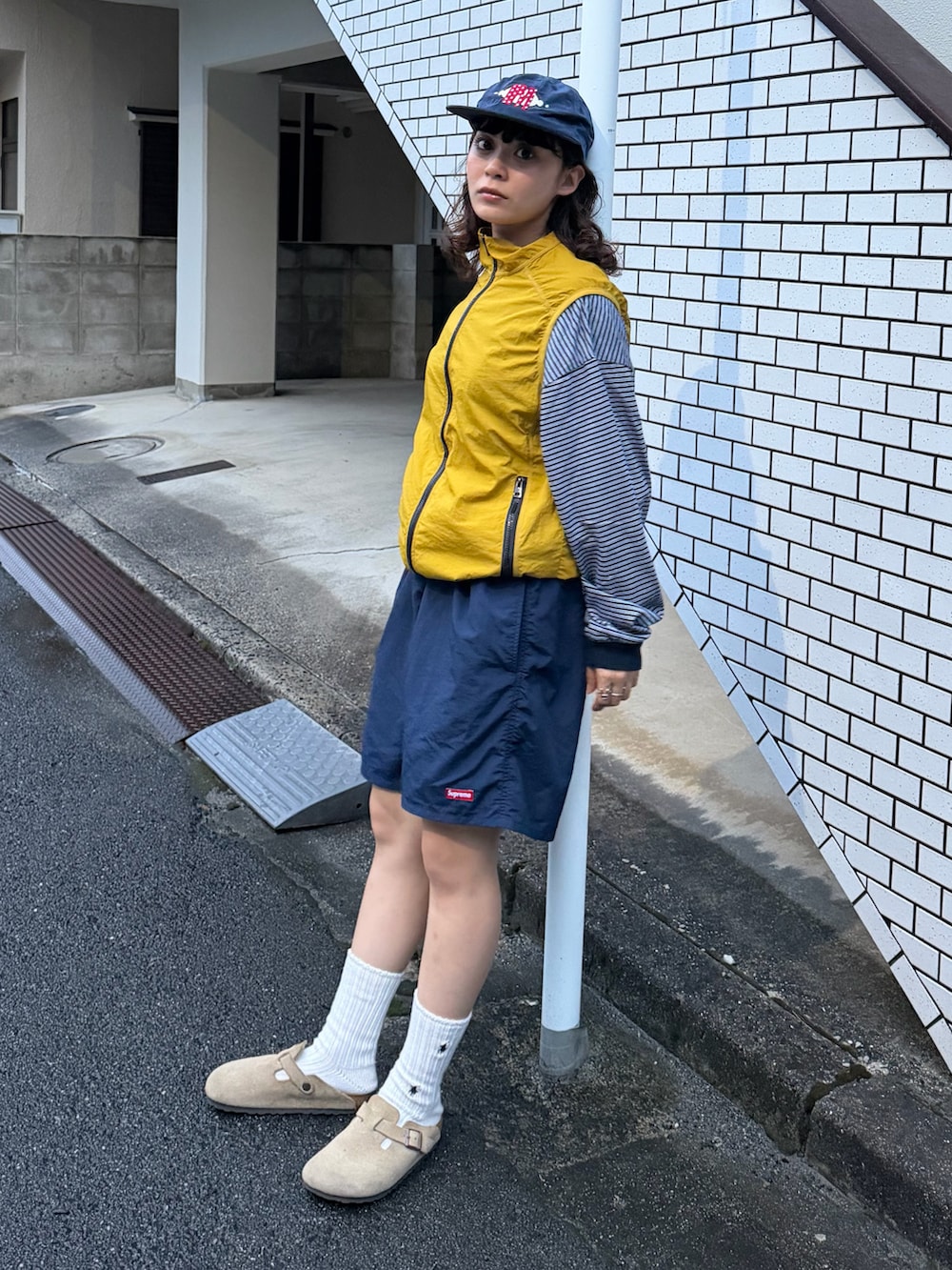 ブルー系のTシャツ/カットソー、ベージュ系のサンダル、ブラック系のトップスを着用したレディースの秋コーディネートの3枚目の写真