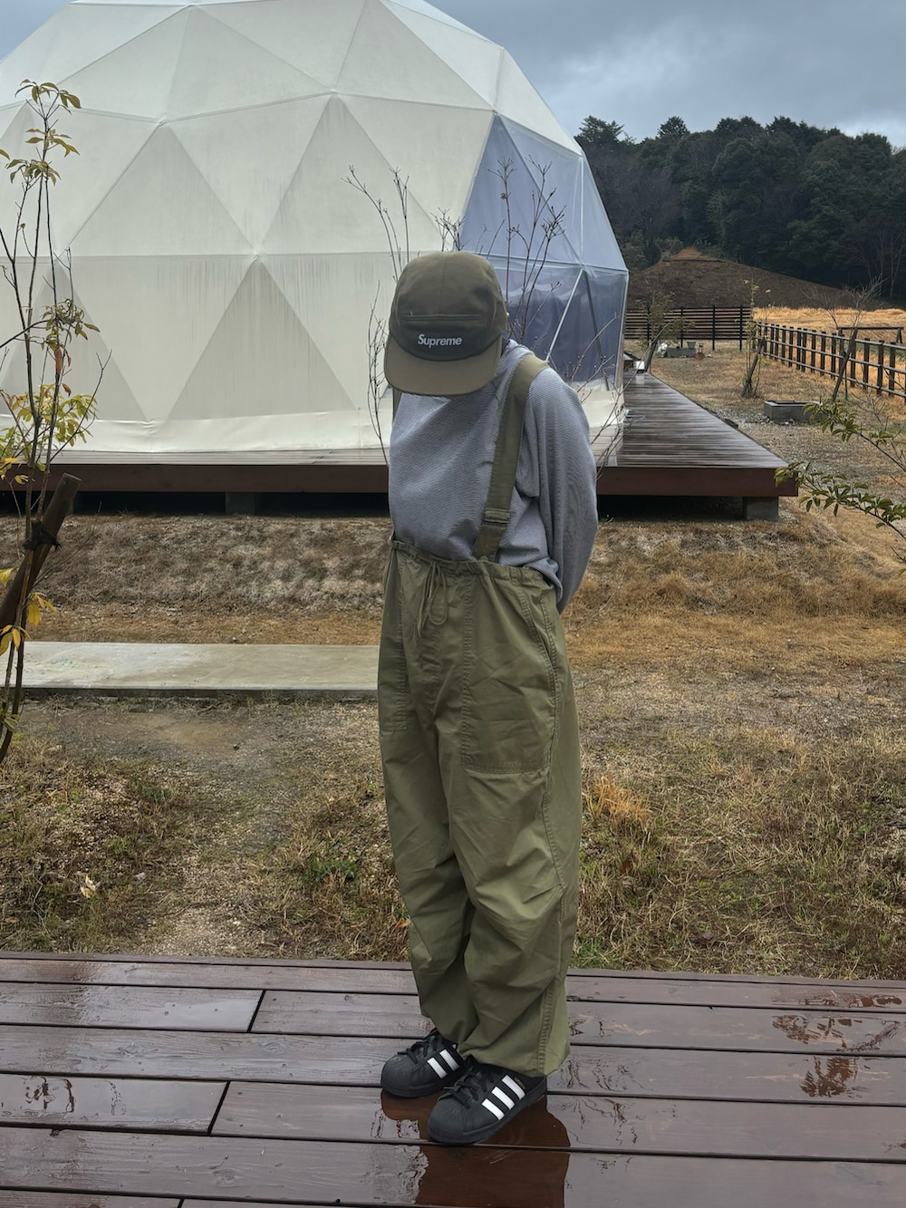 グリーン系のカーゴパンツ、ブラック系のスニーカー、ブラック系のトップスを着用したレディースの春コーディネートの2枚目の写真