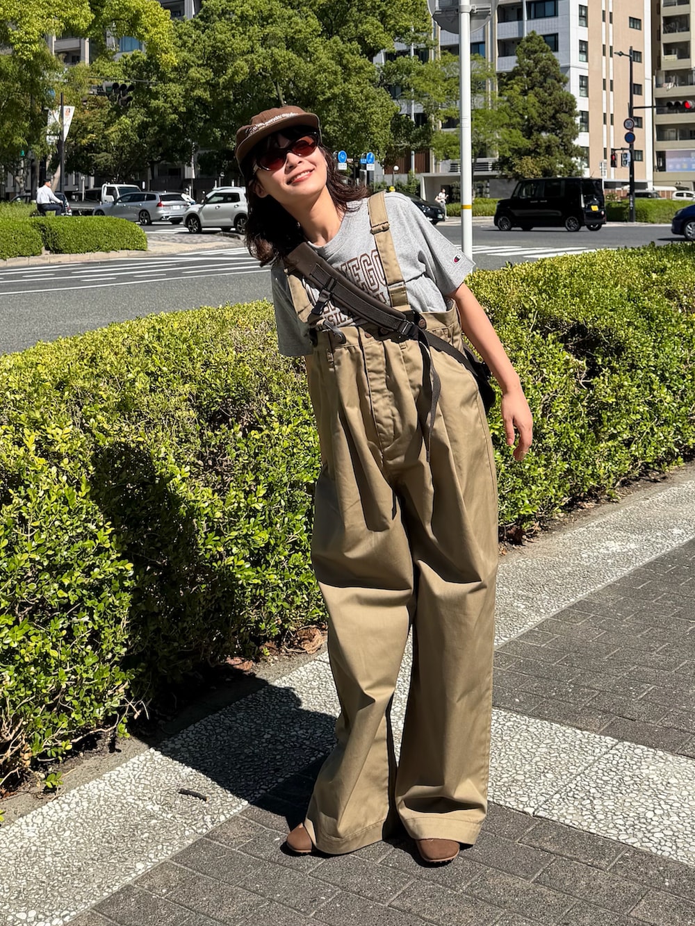 グレー系のTシャツ/カットソー、ベージュ系のチノパンツ、ブラウン系のシューズを着用したレディースの夏コーディネートの2枚目の写真