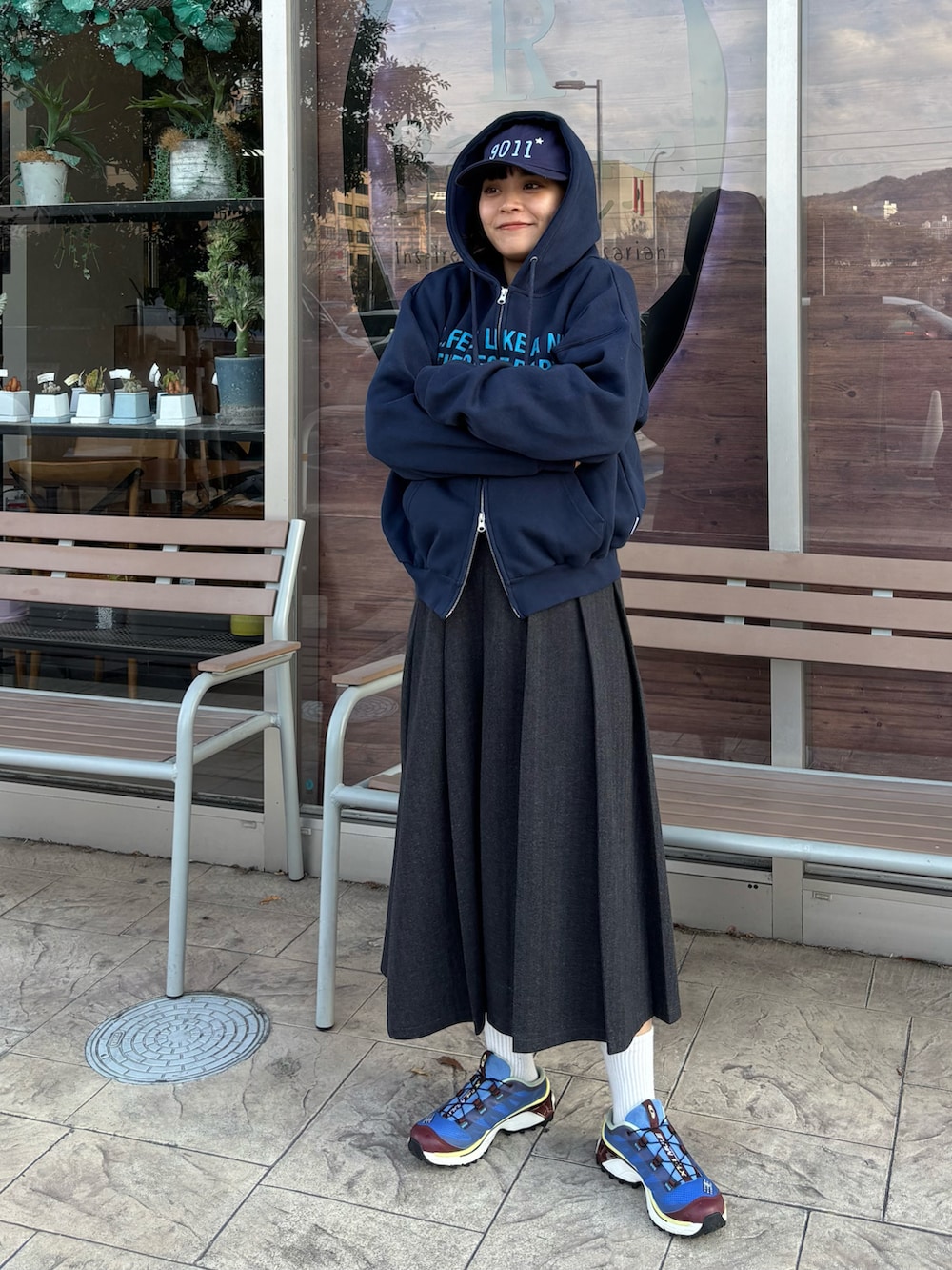 グレー系のスカート、ブルー系のスニーカー、ブルー系のパーカーを着用したレディースの冬コーディネートの2枚目の写真