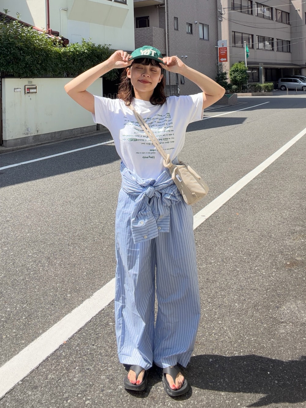 ホワイト系のTシャツ/カットソー、ブルー系のサロペット/オーバーオール、ベージュ系のハンドバッグを着用したレディースの夏コーディネートの2枚目の写真