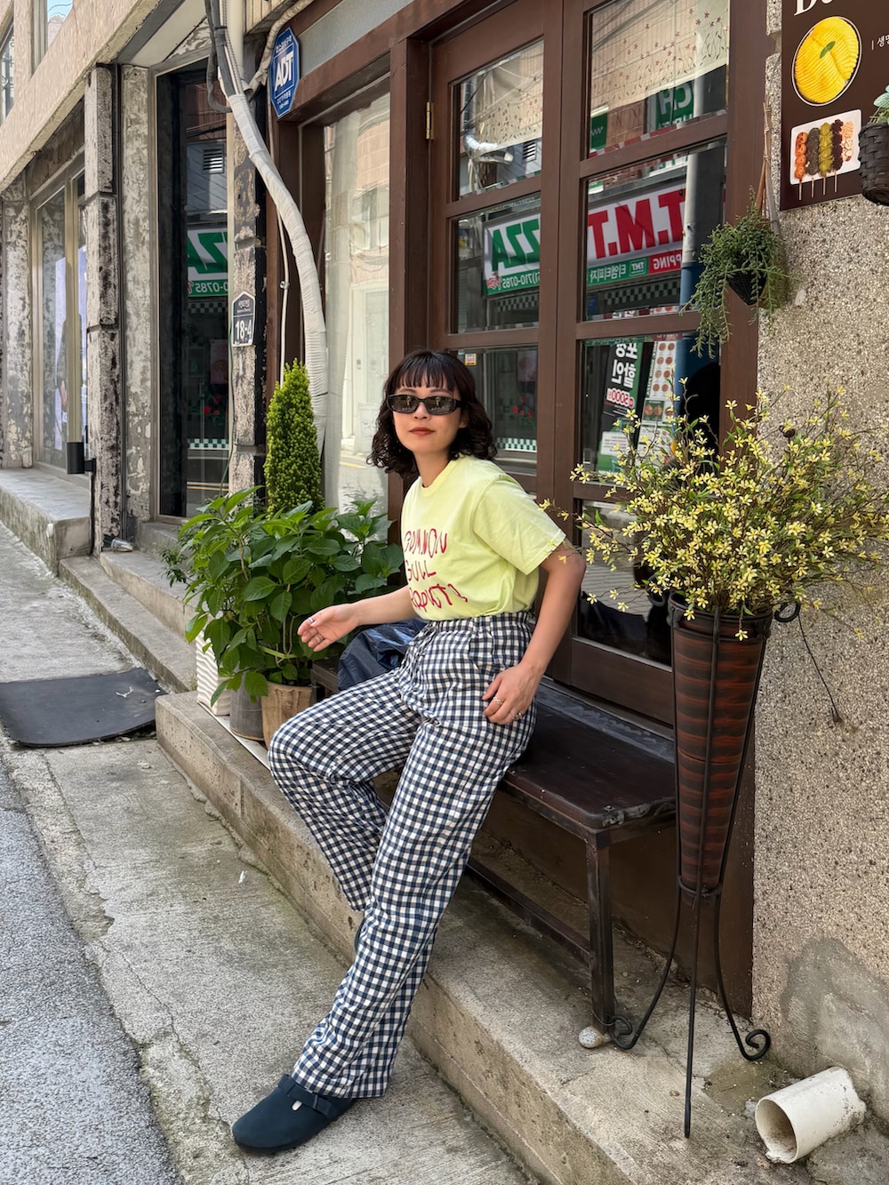 グリーン系のTシャツ/カットソー、ブルー系のパンツ、ブルー系のサンダルを着用したレディースの春コーディネートの3枚目の写真
