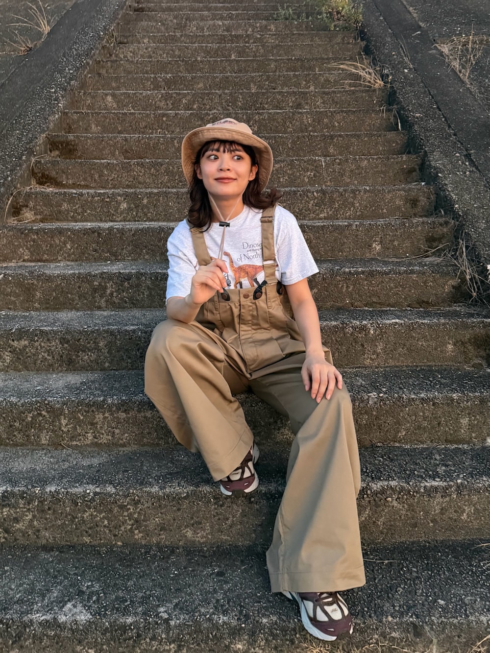 シルバー系のTシャツ/カットソー、ベージュ系のチノパンツ、ブラウン系のシューズを着用したレディースの夏コーディネートの3枚目の写真