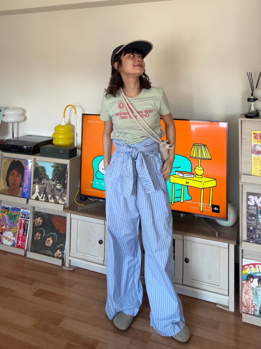 グリーン系のTシャツ/カットソー、ブルー系のサロペット/オーバーオール、ベージュ系のハンドバッグを着用したレディースの夏コーディネートの2枚目の写真