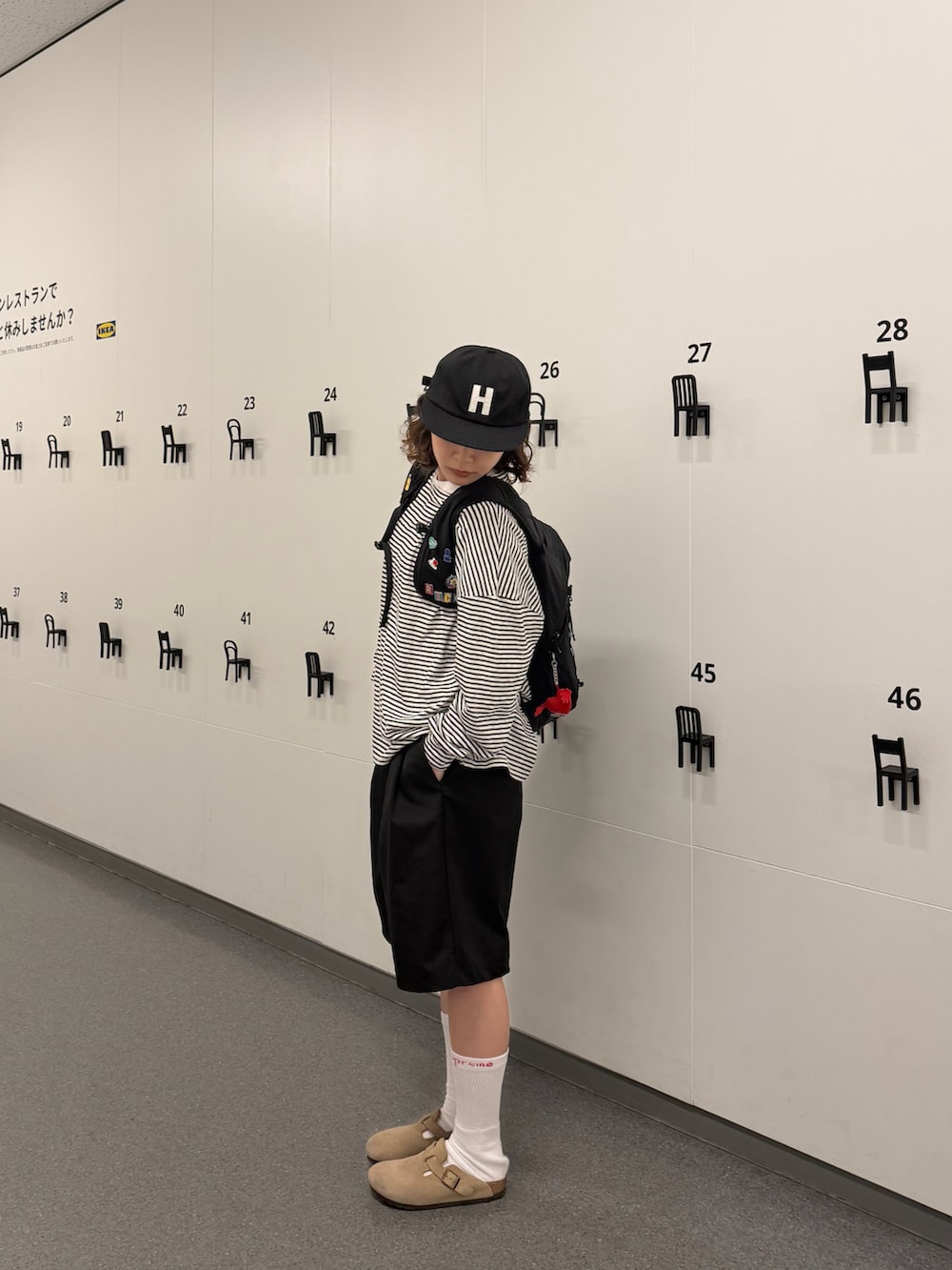 ベージュ系のサンダル、ブラック系のバックパック/リュック、ブラック系のトップスを着用したレディースの春コーディネートの2枚目の写真