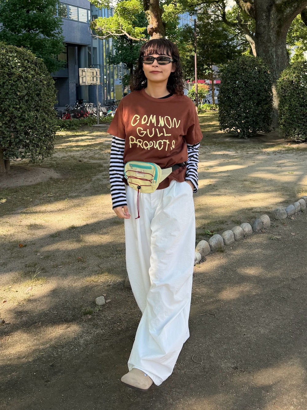 ブラウン系のTシャツ/カットソー、ブラック系のトップス、イエロー系のボディバッグ/ウエストポーチを着用したレディースの秋コーディネートの2枚目の写真