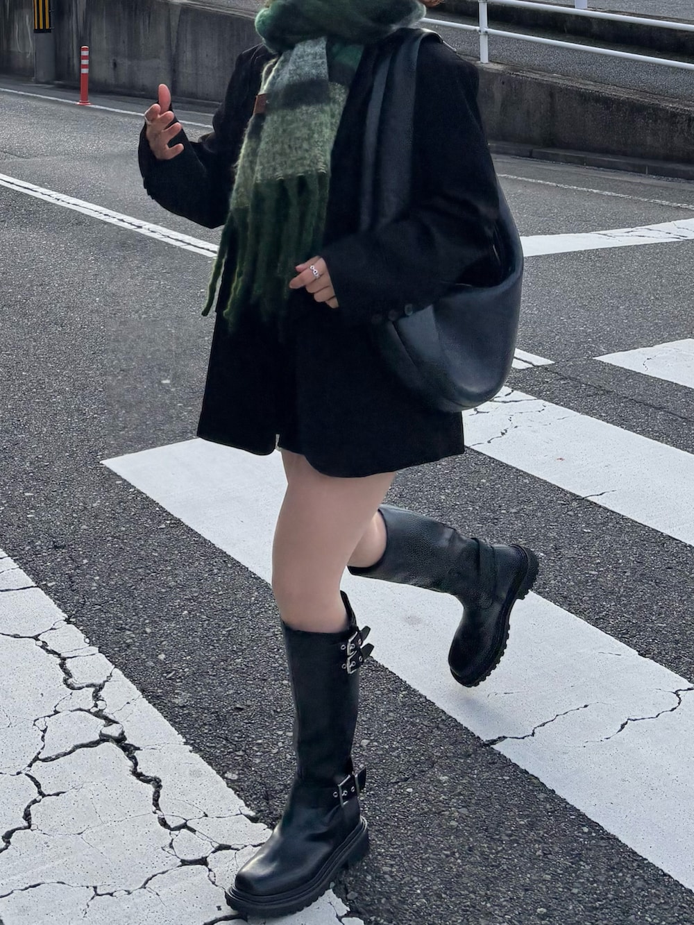 ブラック系のブーツ、ブラック系のショルダーバッグ、ブラック系のテーラードジャケットを着用したレディースの冬コーディネートの2枚目の写真