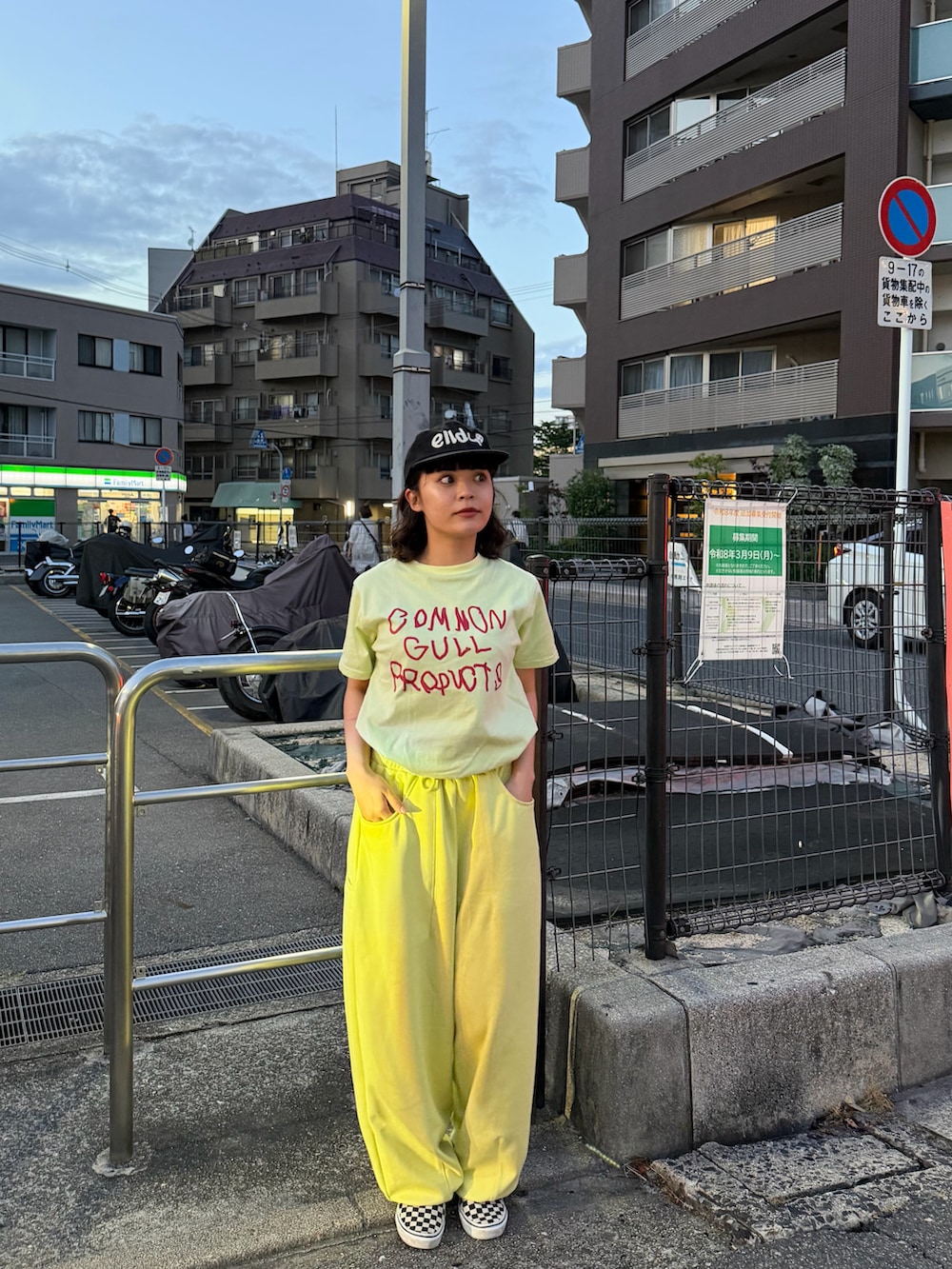 ブラック系のスリッポン、グリーン系のTシャツ/カットソー、イエロー系のスウェットパンツを着用したレディースの春コーディネートの3枚目の写真