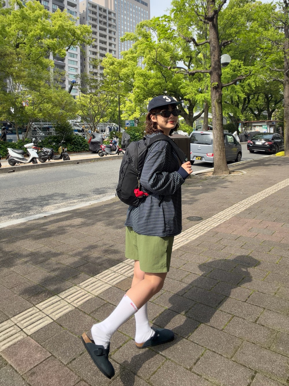 ブラック系のバックパック/リュック、ブルー系のサンダル、ブルー系のTシャツ/カットソーを着用したレディースの春コーディネートの3枚目の写真