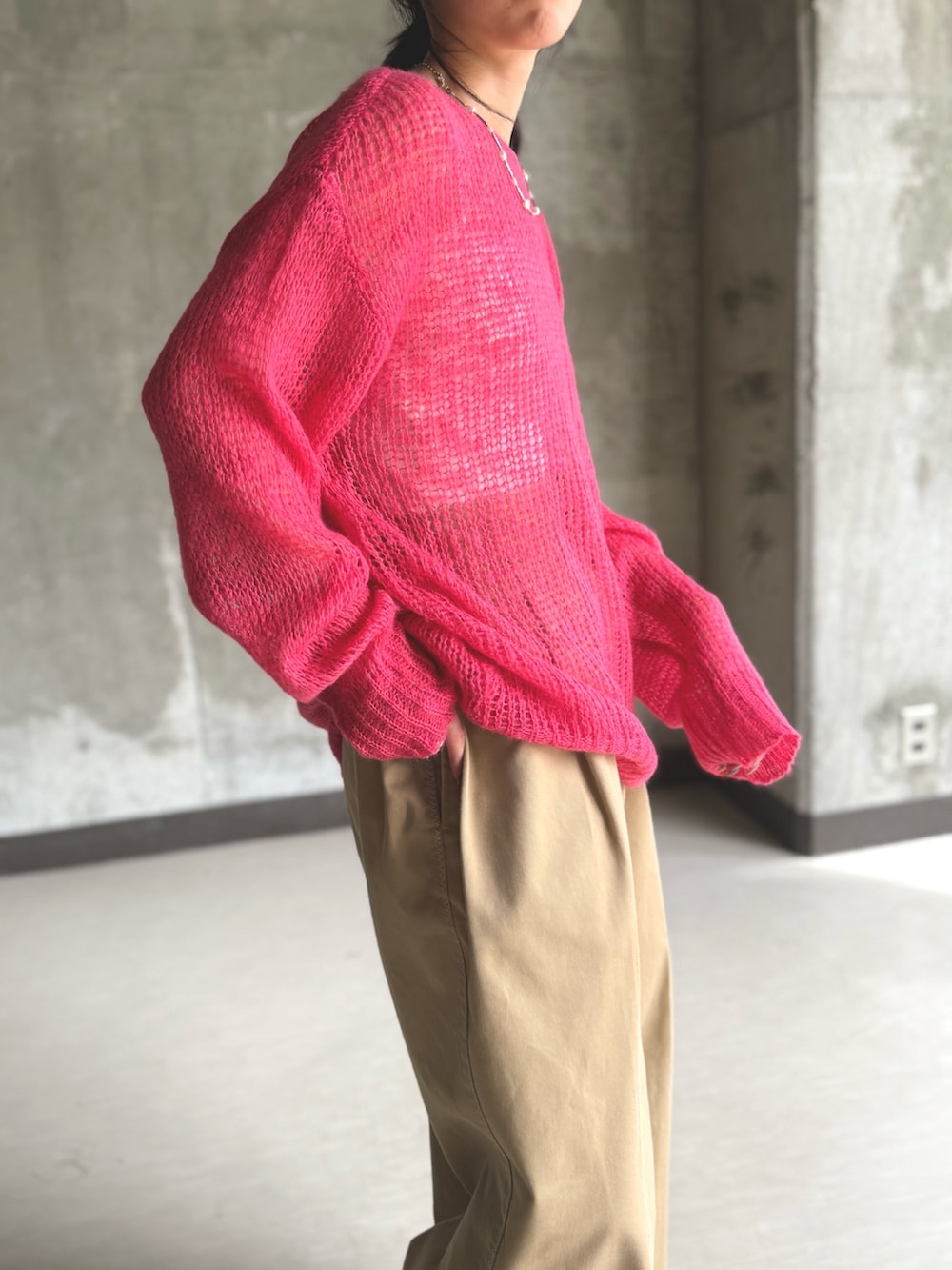 ピンク系のニット/セーター、ベージュ系のチノパンツを着用したレディースの秋コーディネートの3枚目の写真