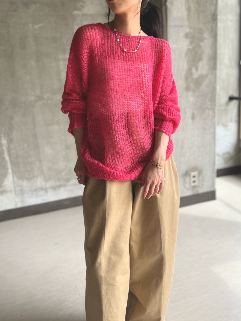 ピンク系のニット/セーター、ベージュ系のチノパンツを着用したレディースの秋コーディネートの2枚目の写真