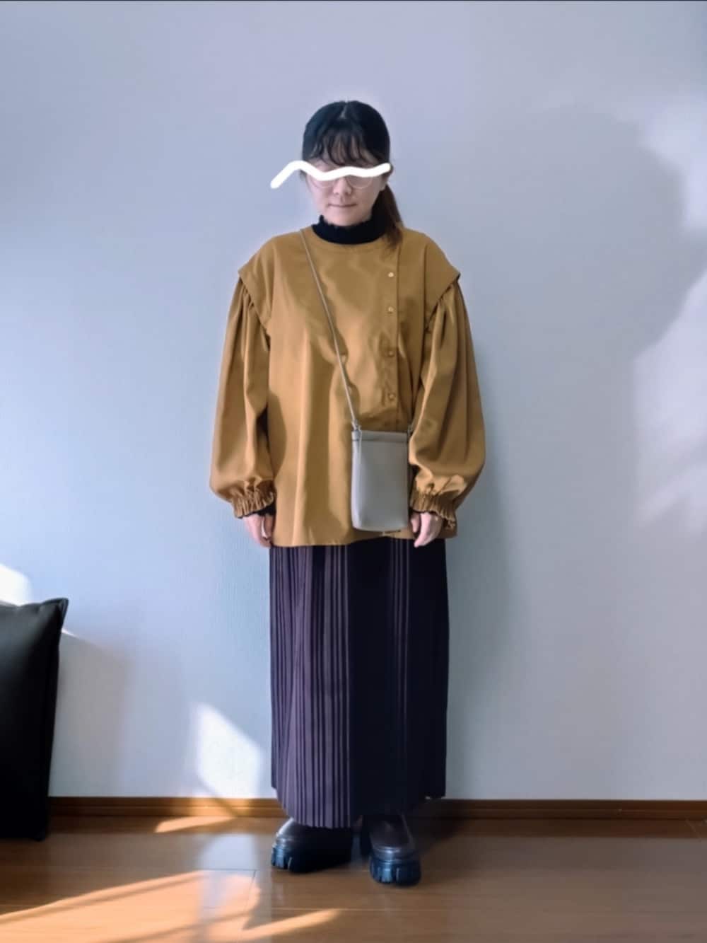 イエロー系のシャツ/ブラウス、ブラック系のTシャツ/カットソー、ブラウン系のスカートを着用したレディースの秋コーディネートの2枚目の写真