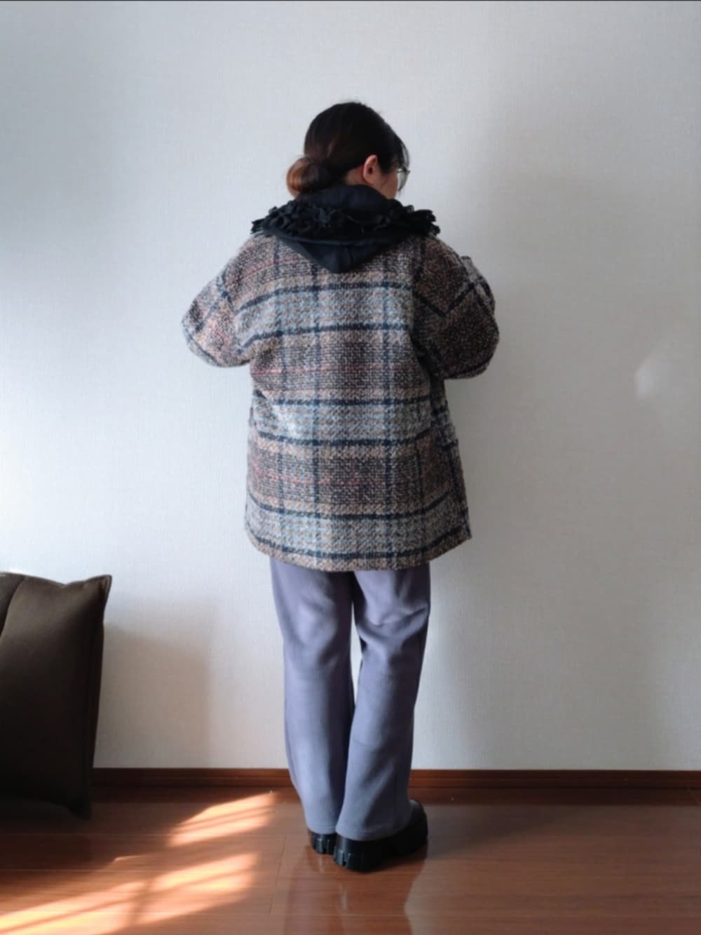 ブラック系のシャツ/ブラウス、ブラウン系のピーコート、ホワイト系のニット/セーターを着用したレディースの冬コーディネートの2枚目の写真