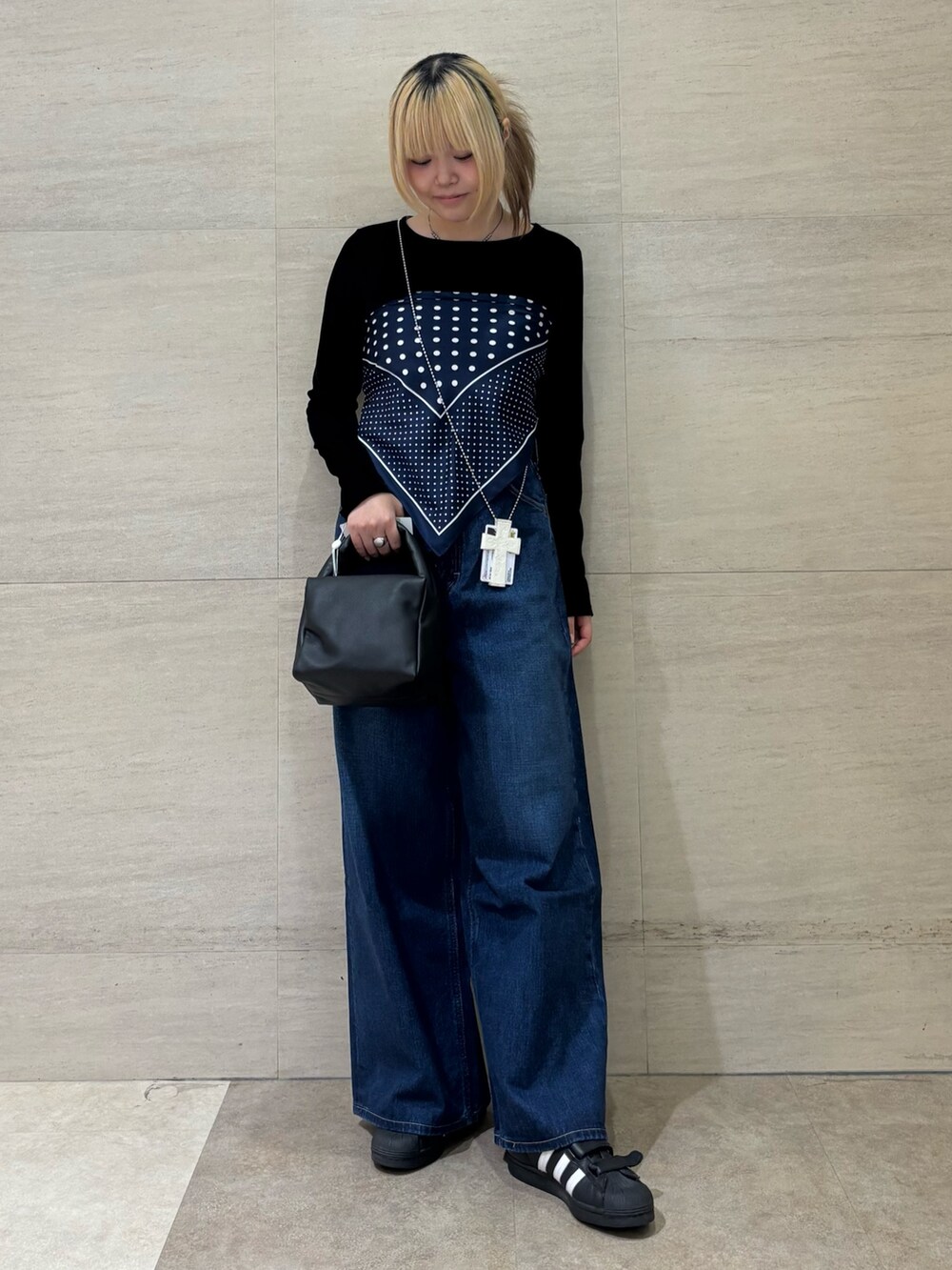 ブルー系のカフリンクス、ブラック系のTシャツ/カットソー、ブルー系のデニムパンツを着用したレディースの秋コーディネートの2枚目の写真