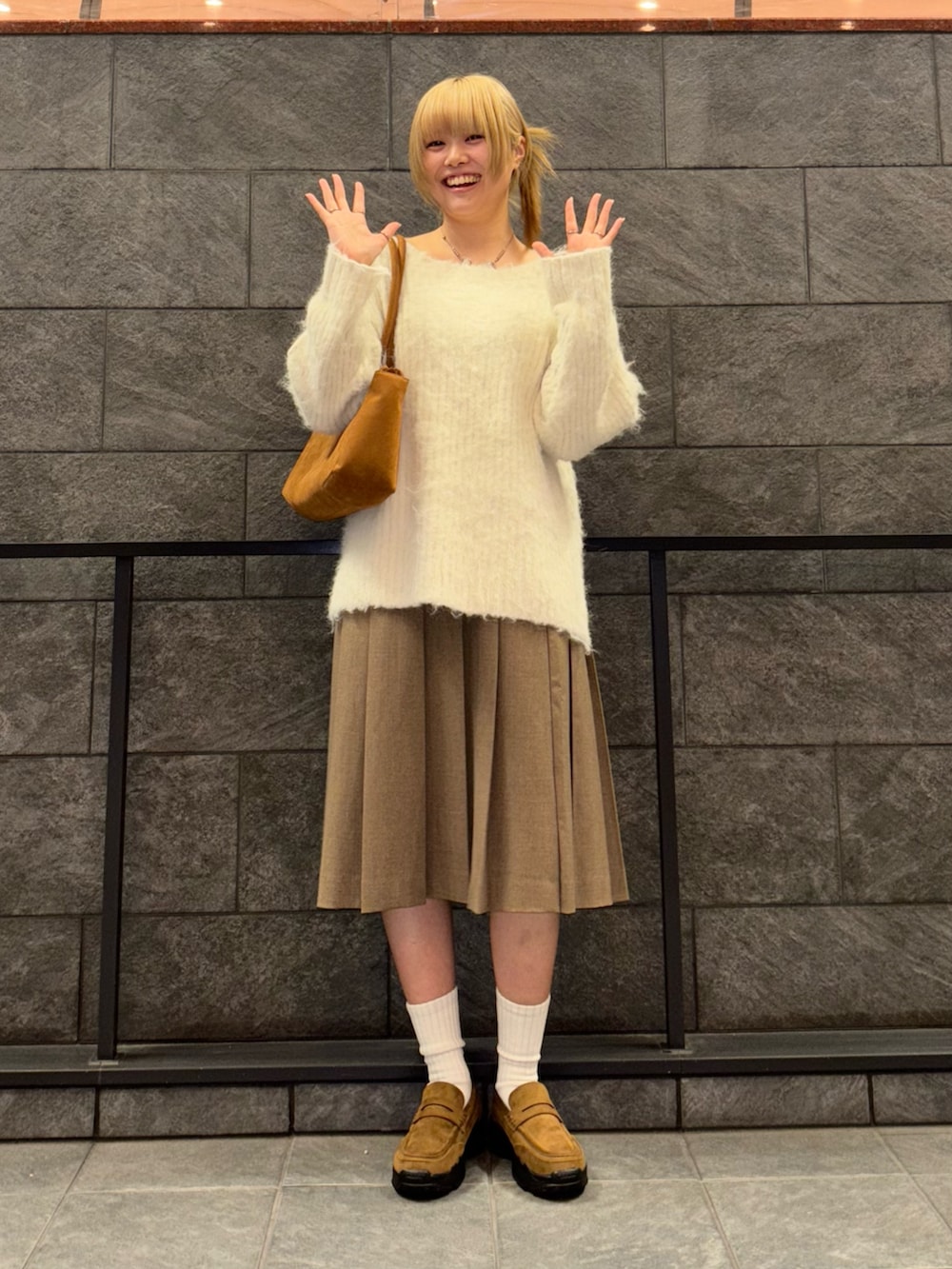 ホワイト系のニット/セーター、ブラウン系のスカート、イエロー系のボストンバッグを着用したレディースの冬コーディネートの4枚目の写真