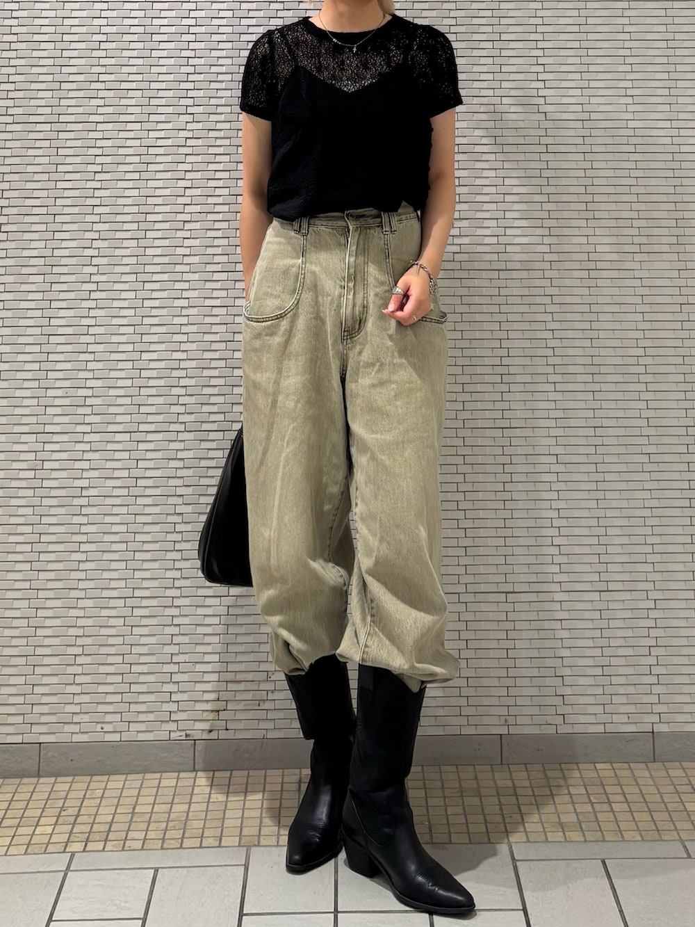 ブラック系のTシャツ/カットソー、グリーン系のデニムパンツを着用したレディースの夏コーディネートの3枚目の写真