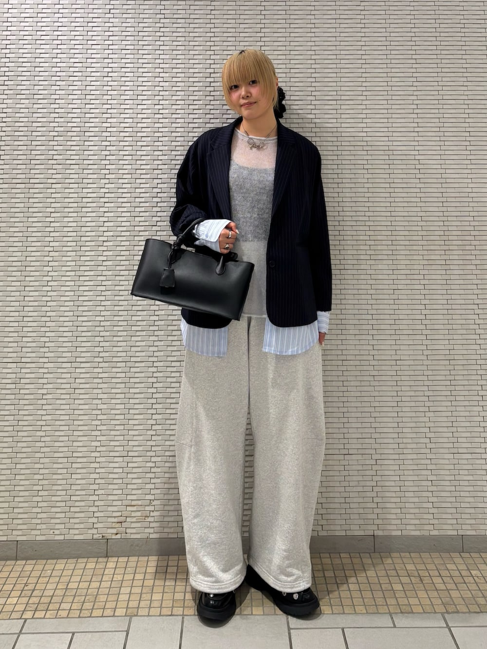 ブルー系のその他アウター、ブルー系のニット/セーター、ブラック系のハンドバッグを着用したレディースの春コーディネートの3枚目の写真